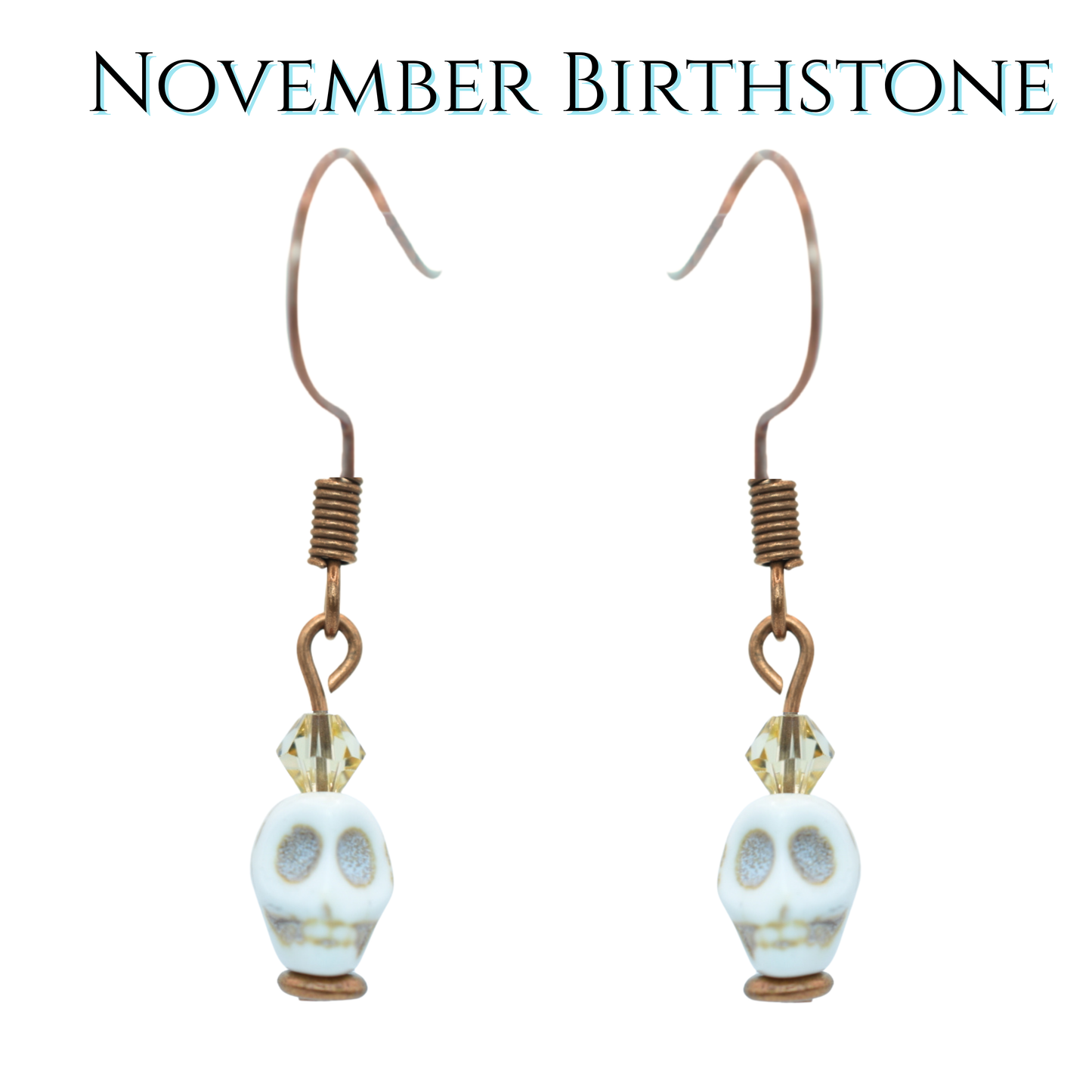 Skull-shaped earrings with topaz tan crystal beads on a white background, labeled 'November Birthstone'.