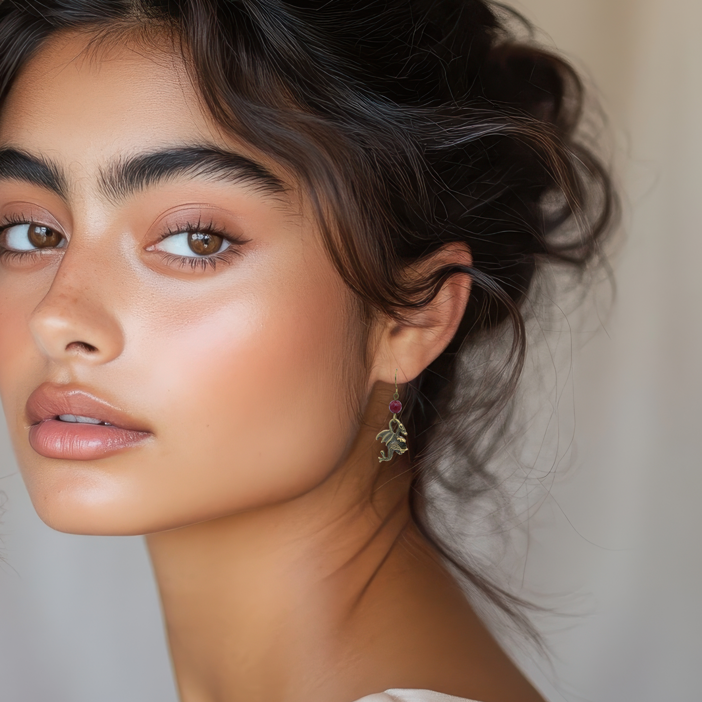 Close-up of a woman wearing a dragon earring with a neutral background