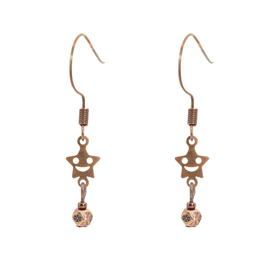 Pair of antique copper star-shaped smiley facew earrings on a white background