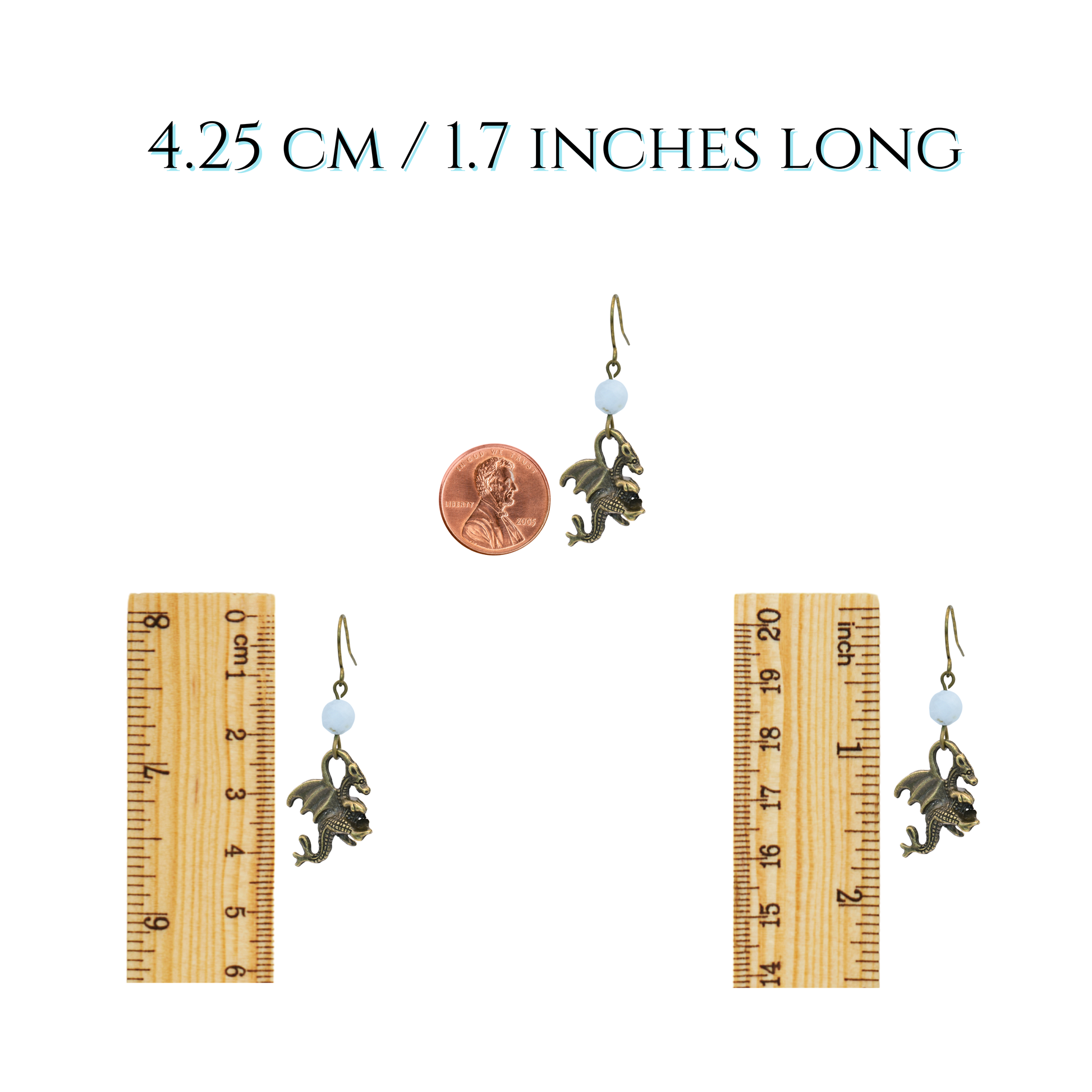 Pair of earrings with a penny and two rulers for size reference on a white background