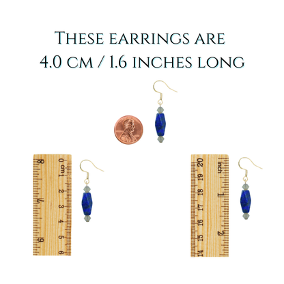 Pair of earrings with a penny and ruler for size reference on a white background