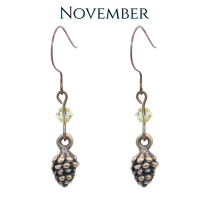 Pine cone earrings with a November theme on a white background