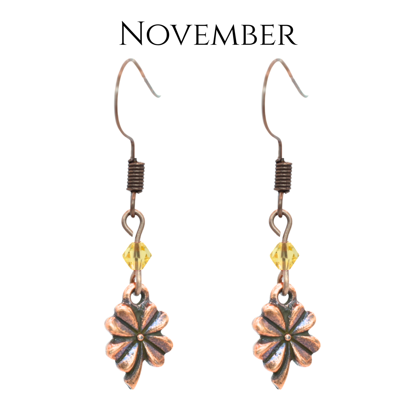earrings featuring antique copper four leaf clover charms and Austrian crystal beads in November birthstone colors