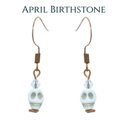 Earrings with skull beads and crystal beads on a white background, labeled 'April Birthstone'.