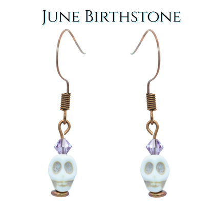 Earrings with white skull and light purple crystals beads on a white background, labeled 'June Birthstone'.
