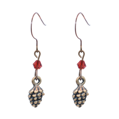 Pair of copper pinecone-shaped earrings with red crystal beads on a white background