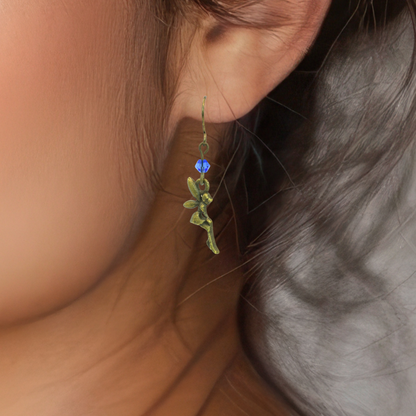 Close-up of a person wearing a fairy earring with a blue crystal.