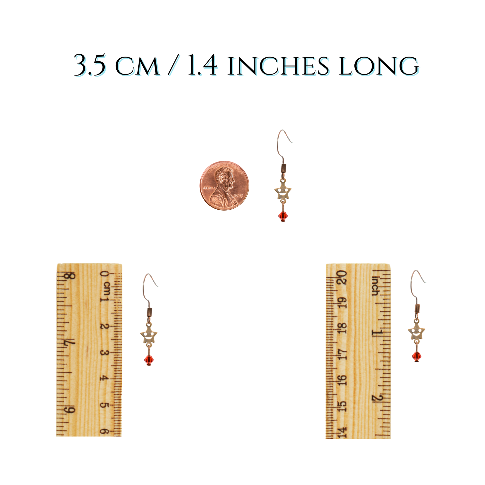 Pair of earrings with a ruler and penny for size reference on a white background