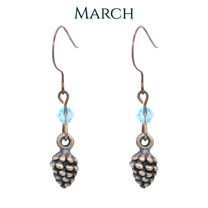Pinecone-shaped earrings with light blue crystal beads on a white background, labeled 'MARCH'.