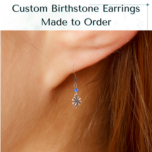Custom birthstone earring worn on an ear with text 'Custom Birthstone Antique Copper Crystal Four Leaf Clover Earrings Made to Order'.