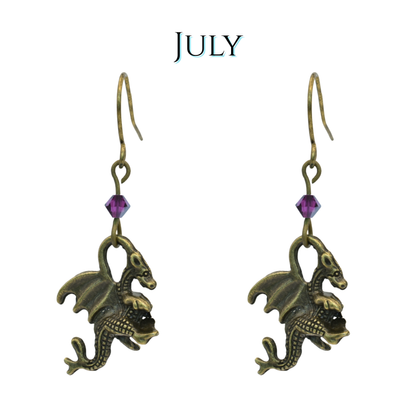 earrings featuring antique bronze dragon charms and dark pink crystal beads, image has text "July"