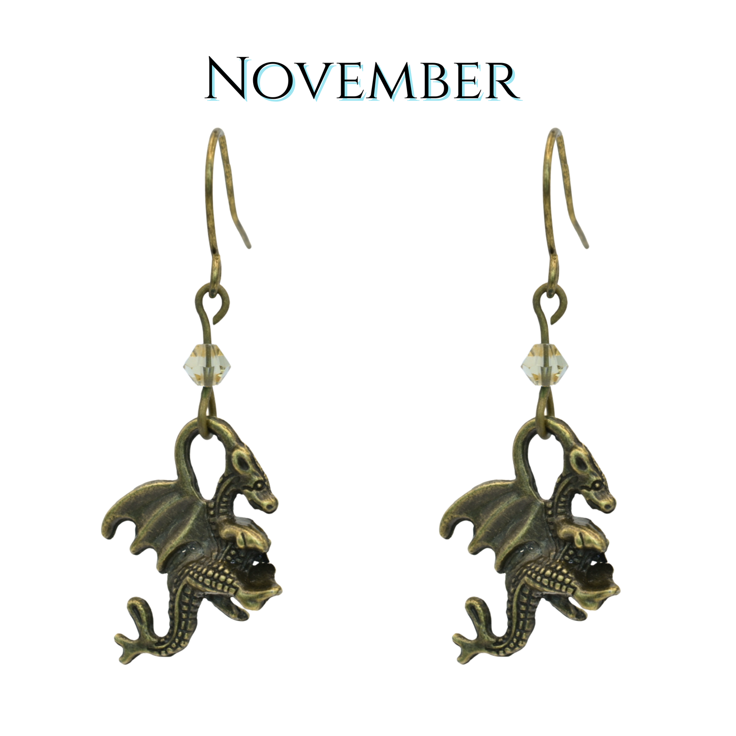 earrings featuring antique bronze dragon charms and tan crystal beads, image has text "November"
