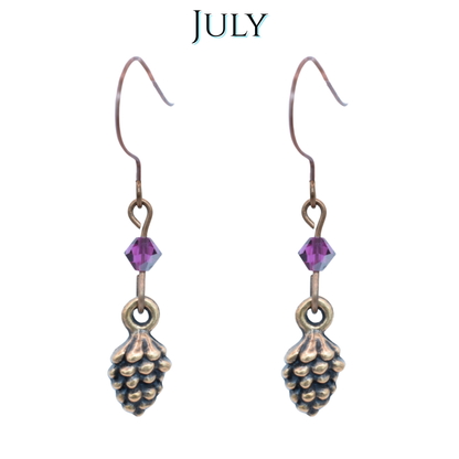 Antique copper earrings with fuchsia pink crystal beads on a white background, labeled 'JULY'.