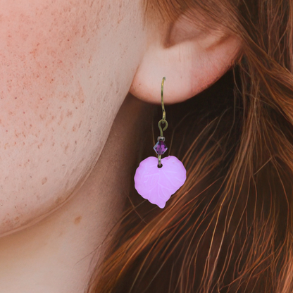 Close-up of a person wearing a pink leaf-shaped earring.