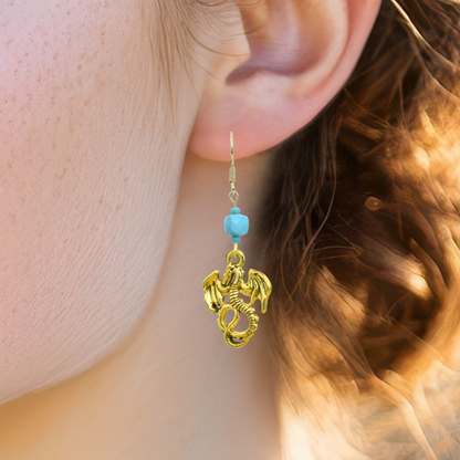 Gold dragon earring with turquoise bead worn by a person