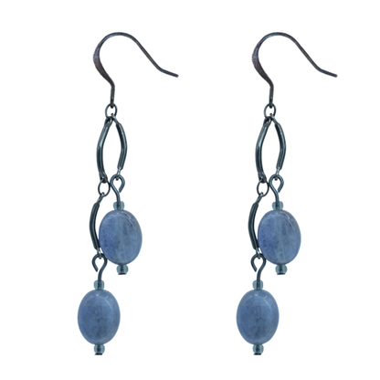 Pair of earrings with tanzanite beads and black metal loops on a white background