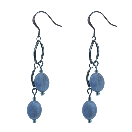 Pair of earrings with tanzanite beads and black metal loops on a white background