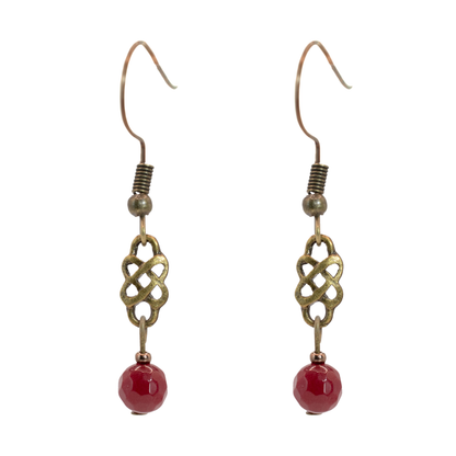 Pair of earrings with antique gold Celtic knot design and red jade beads on a white background