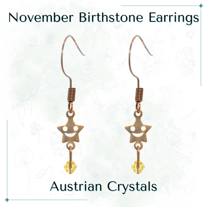 Star-shaped earrings with topaz beads labeled 'November Birthstone Earrings' and 'Austrian Crystals' on a white background.