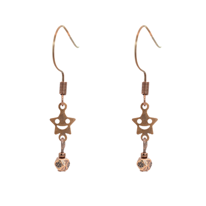 Pair of antique copper star-shaped smiley facew earrings on a white background