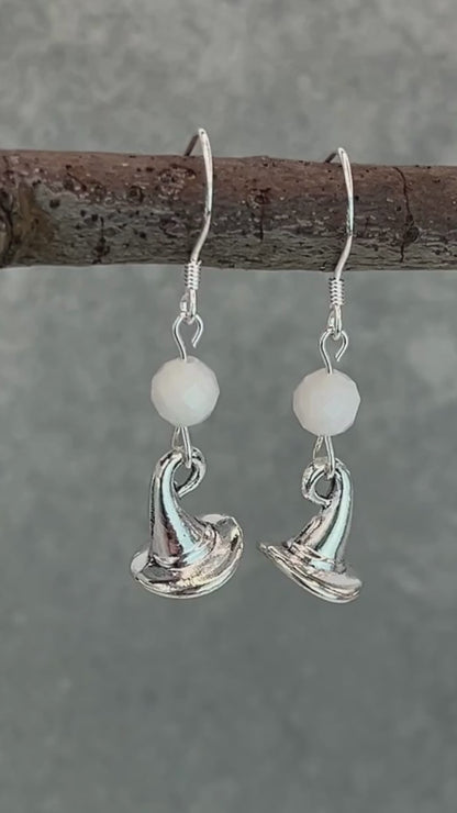 a video of silver earrings featuring white moonstone round faceted beads and witch hat charms